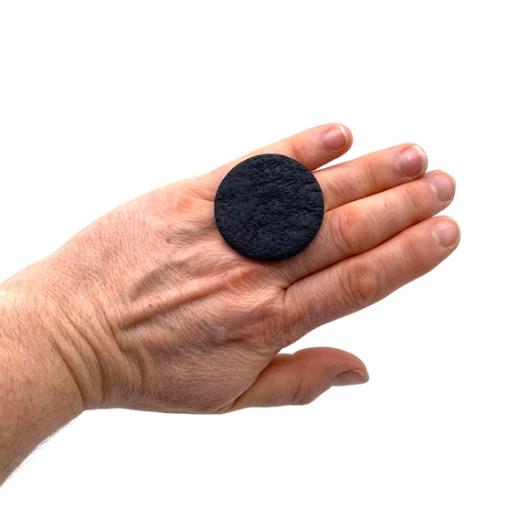 Someone wearing a Black Large Polymer Clay Ring against a white background