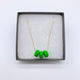 Bright Green polymer clay beads on a gold plated stainless steel chain in a box on a white background