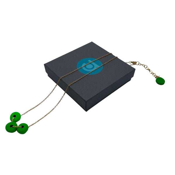 Bright Green polymer clay beads on a gold plated stainless steel chain on a box on a white background