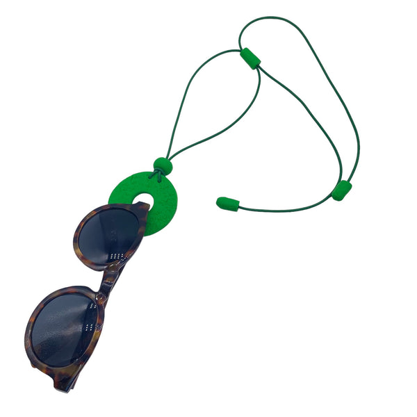 Bright Green Polymer clay necklace and glasses holder holding sunglasses with on a white background