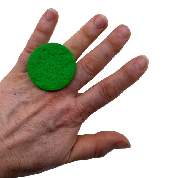 Someone wearing a Bright Green Large Polymer Clay Ring against a white background