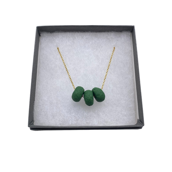 Dark Green polymer clay beads on a gold plated stainless steel chain in a box on a white background