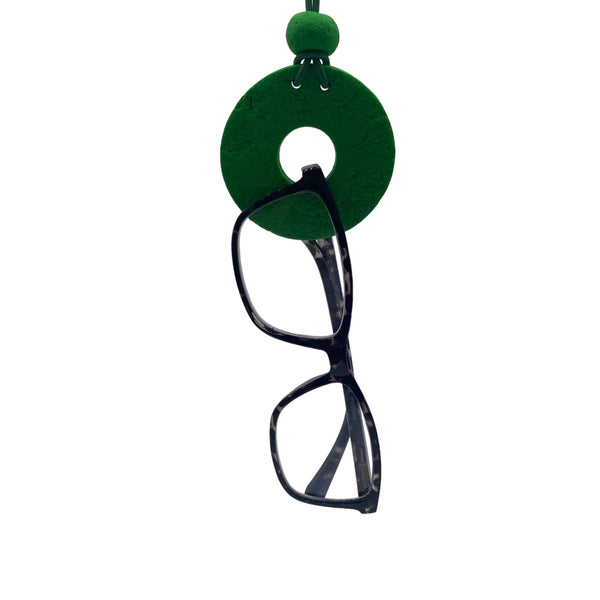 Dark Green Small Circle Necklace with hole holding glasses on a white background