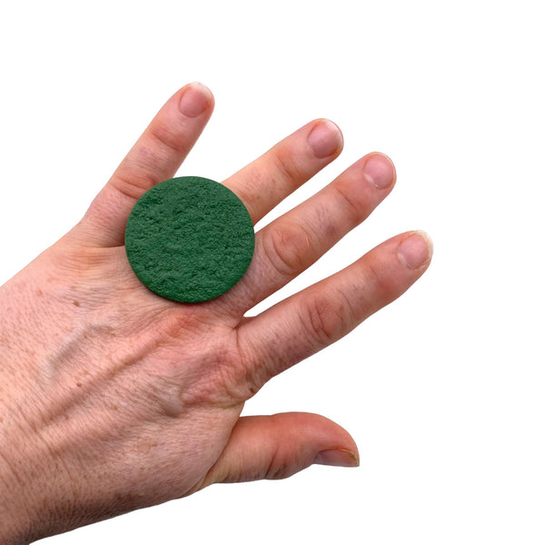 Someone wearing a Dark Green Large Polymer Clay Ring against a white background