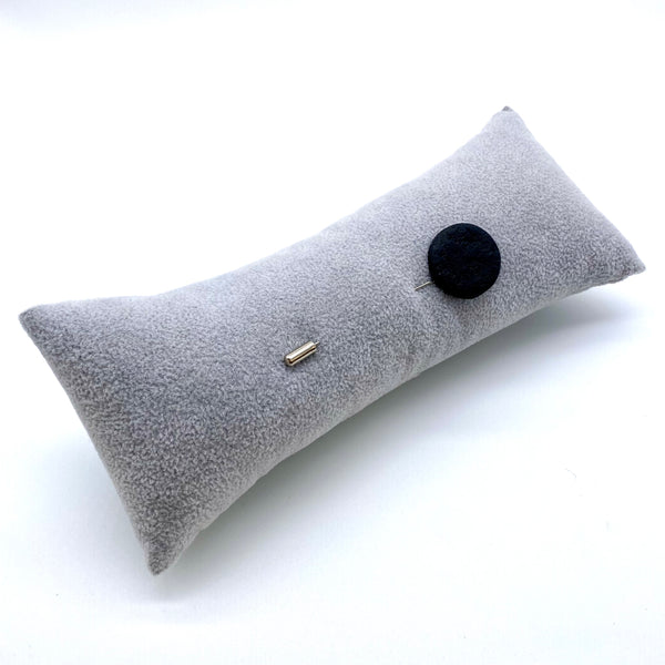 Black Polymer Clay Lapel Pin with stainless steel pin on a  grey cushion on a white background