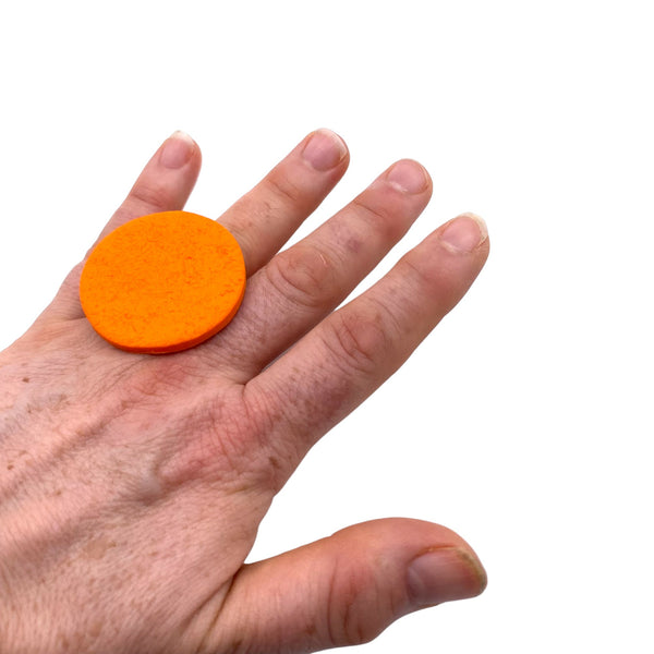 Someone wearing Orange Large Polymer Clay Ring against a white background