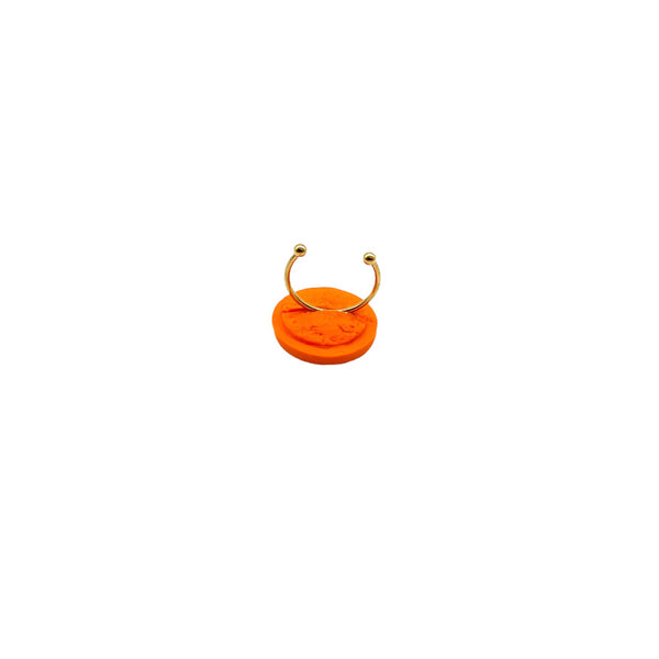 Orange small polymer clay ring on a white background