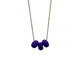 Purple polymer clay beads on a gold plated stainless steel chain on a white background