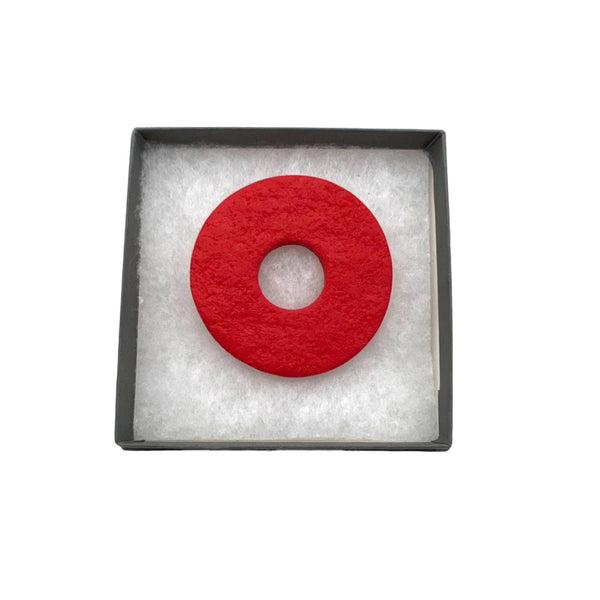 Red polymer clay brooch in a box on a white background