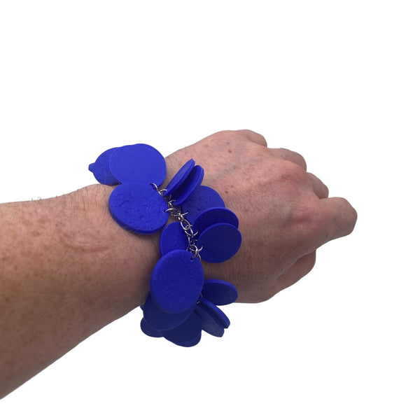 someone's wrist wearing a Royal Blue polymer clay bracelet on white background