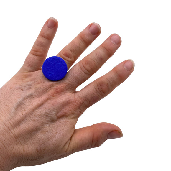 Someone wearing a Royal Blue small polymer clay ring on a white background