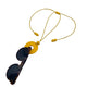 Yellow polymer clay statement necklace and glasses holder holding sunglasses on a white background