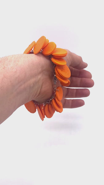 Video of Someone's wrist wearing an Orange polymer clay bracelet on white background