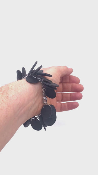 Video showing someone's wrist when wearing a Black  polymer clay bracelet on a white background