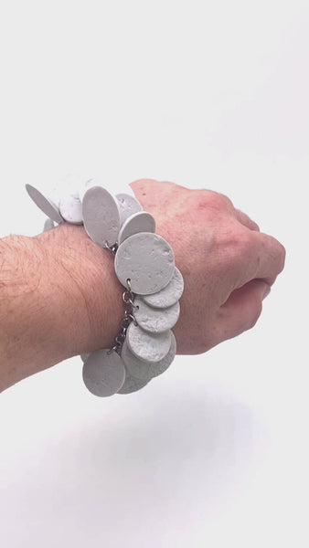 Video of Someone's wrist wearing a Grey polymer clay bracelet on white background