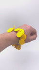 Video of Someone's wrist wearing a Yellow polymer clay bracelet on white background