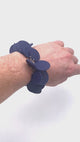 Video showing someone's wrist  wearing a  Navy Blue polymer clay bracelet on white background