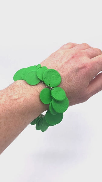 Video of someone's wrist wearing a Bright Green polymer bracelet on a white background 