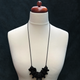 Black Disc and Bead Polymer Clay statement necklace with coordinating elastic cord on a mannequin to show the various lengths it can be worn