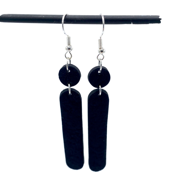 Black Polymer Clay Dangle earrings with shepherd hooks dangling from a black hanger