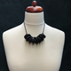 Black Disc and Bead Polymer Clay statement necklace with coordinating elastic cord on a mannequin to show the various lengths it can be worn