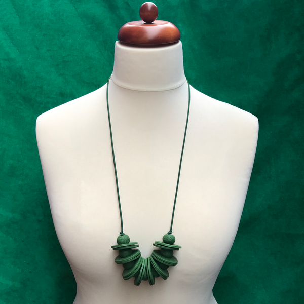 Dark Green Disc and Bead Polymer Clay statement necklace with coordinating elastic cord on a mannequin to show the various lengths it can be worn