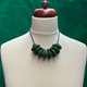 Dark Green Disc and Bead Polymer Clay statement necklace with coordinating elastic cord on a mannequin to show the various lengths it can be worn