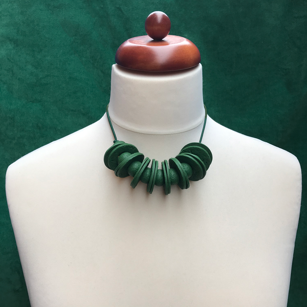 Dark Green Disc and Bead Polymer Clay statement necklace with coordinating elastic cord on a mannequin to show the various lengths it can be worn