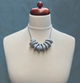 Grey Disc and Bead Polymer Clay statement necklace with coordinating elastic cord on a mannequin to show the various lengths it can be worn