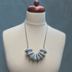 Grey Disc and Bead Polymer Clay statement necklace with coordinating elastic cord on a mannequin to show the various lengths it can be worn