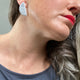 Someone wearing grey polymer clay half circle stud earrings