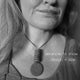 Black and white image showing someone wearing disc pendant statement Christie necklace