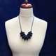 Navy Blue Disc and Bead Polymer Clay statement necklace with coordinating elastic cord on a mannequin to show the various lengths it can be worn