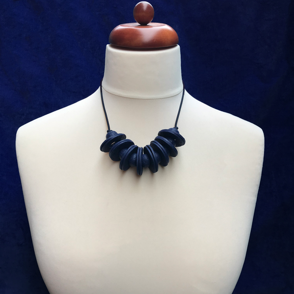 Navy Blue Disc and Bead Polymer Clay statement necklace with coordinating elastic cord on a mannequin to show the various lengths it can be worn