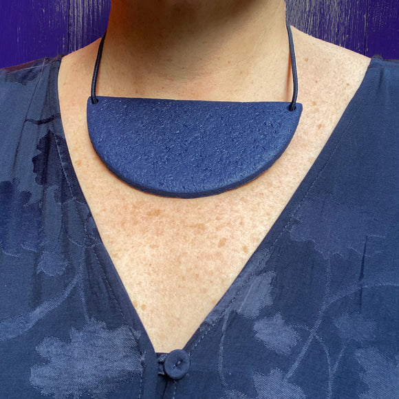 someone wearing Navy Blue half circle polymer clay statement necklace with coordinating elastic cord