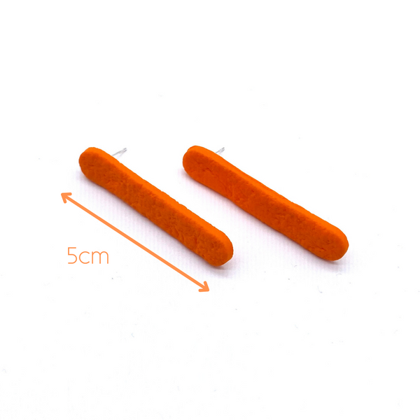 Orange polymer clay long straight stud earrings showing length of earrings