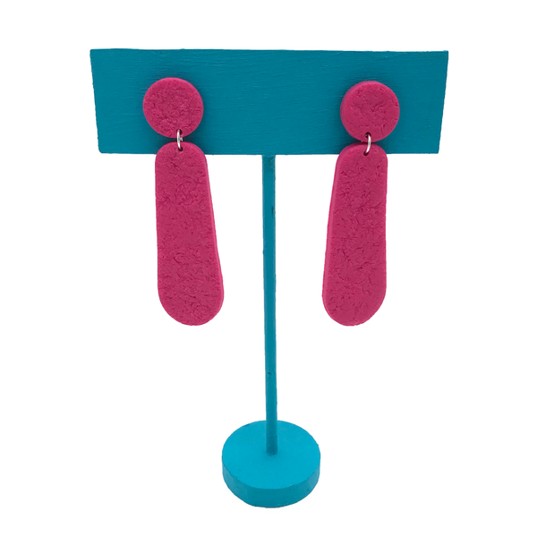 Pink polymer clay dangle earrings on turquoise stand