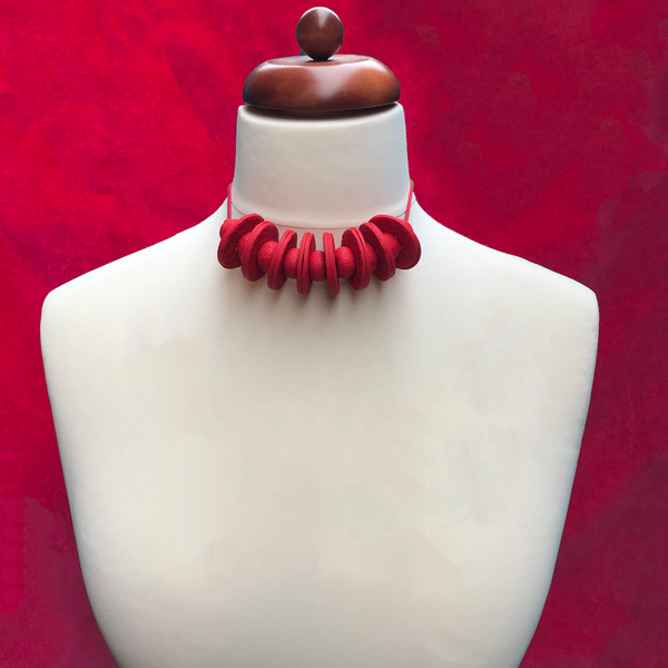 Red Disc and Bead Polymer Clay statement necklace with coordinating elastic cord on a mannequin to show the various lengths it can be worn