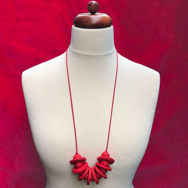 Red Disc and Bead Polymer Clay statement necklace with coordinating elastic cord on a mannequin to show the various lengths it can be worn