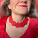 Someone wearing a Red polymer clay statement necklace with coordinating red elastic cordC