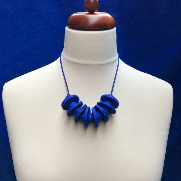 Royal Blue Disc and Bead Polymer Clay statement necklace with coordinating elastic cord on a mannequin to show the various lengths it can be worn