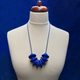 Royal Blue Disc and Bead Polymer Clay statement necklace with coordinating elastic cord on a mannequin to show the various lengths it can be worn