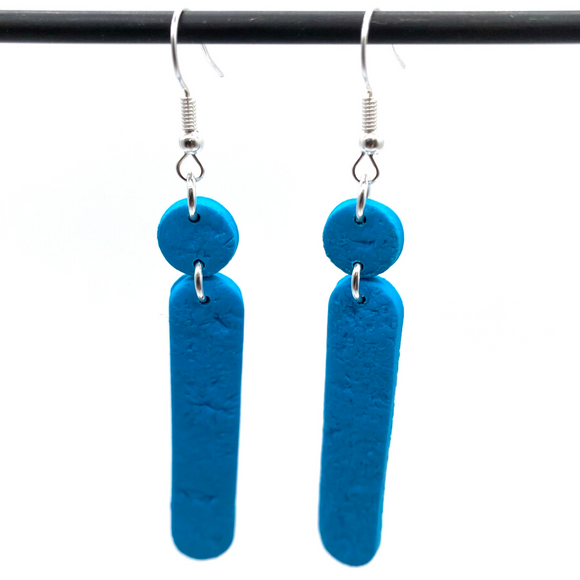 Turquoise Polymer Clay Dangle earrings with shepherd hooks dangling from a dark hanger