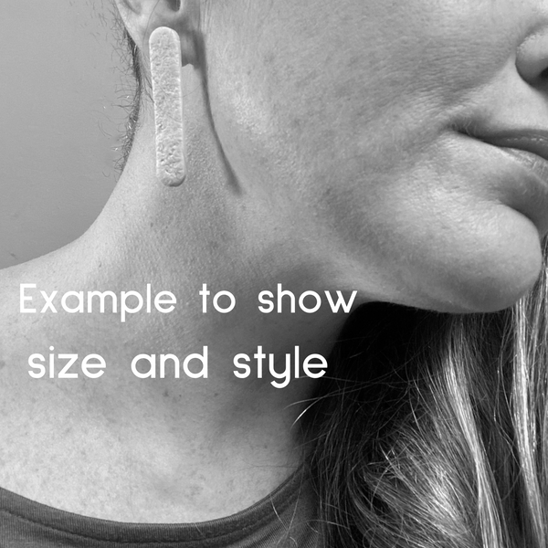 Someone wearing polymer clay long straight stud earrings. Image is in black and white to show size and style of earring